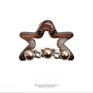 Star-shaped amber resin hair claw clip with brown pearls and sparkling crystals