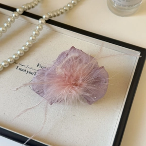 Detail view of the purple feather hair claw clip with delicate mesh and rhinestones
