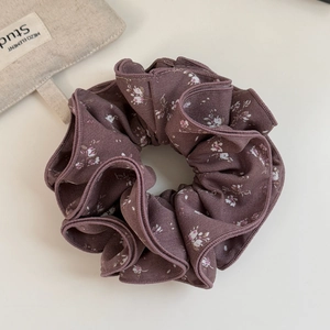 Detailed close-up of grey purple floral chiffon scrunchie with layered fabric texture