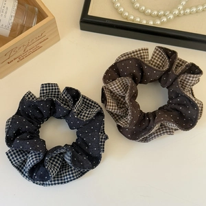 Detail of elegant polka dot and plaid patchwork fabric scrunchies in navy and brown