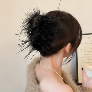 Détail d'une pince à cheveux en plumes noires duveteuses sur un modèle pour un look d'hiver chic