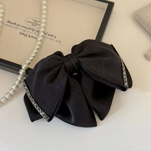 Dettaglio di un fermaglio per capelli in seta nera con strass argentati in stile vintage
