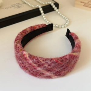 Close-up of red plaid tweed texture on padded wide headband for elegant winter style