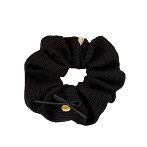 Black knitted scrunchie with a bow, cherry pendant and Hand Made label on white background
