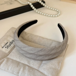Gros plan du serre-tête tressé gris avec doublure antidérapante et motif à rayures chic