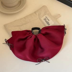 Detail of dark red satin bow hair claw with silver rhinestone charms and powerful grip