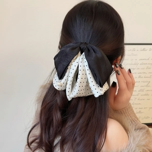 Polka dot bow hair claw clip with pearl pendants on brunette hair seen from behind