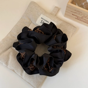 Chouchou élégant avec imprimé léopard et satin noir pour les coiffures chic des femmes