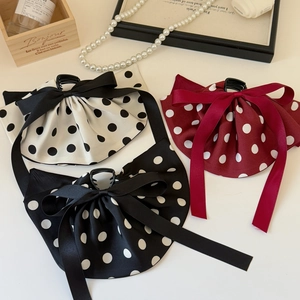 Pinces à cheveux à pois style français en blanc, rouge et noir sur un plateau en bois