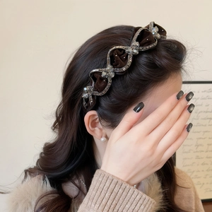 Close-up of wavy dark brown velvet headband with sparkling rhinestones on a model