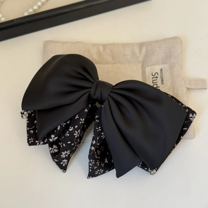 Detail of floral bow hair claw clip with contrast ribbon and sparkling rhinestone pendant