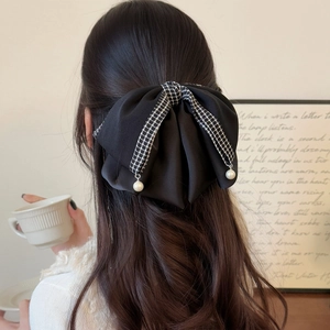 Elegant black bow hair claw clip with houndstooth trim and hanging pearls on back of head