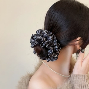 Detailed close-up of a large black and white checkered scrunchie on a hair bun
