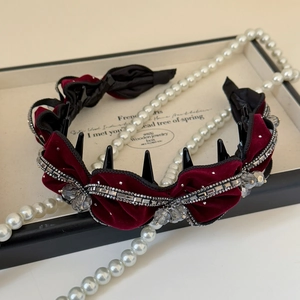 Close-up of luxury burgundy velvet headband with crystal beads and spiked accents