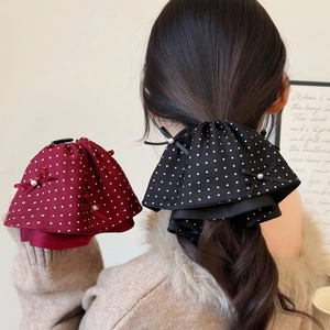 Detailed view of polka dot bow hair clips with pearls in black and burgundy colors