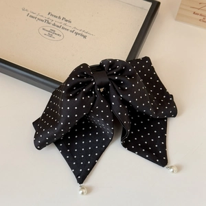 Détail de la pince à cheveux française à pois noirs avec pendentifs en perles blanches