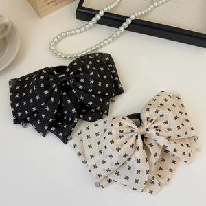 Elegant polka dot bow hair claw clip in black and beige with textured chiffon layers