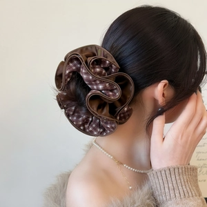 Macro detail of brown satin and checkered fabric layered hair scrunchie accessory