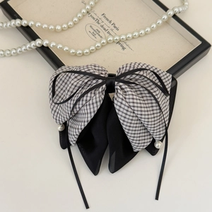 Close-up of French plaid bow hair clip with black chiffon and hanging pearl details