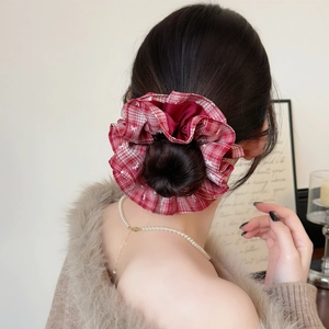 Red plaid scrunchie with white bow embroidery on an elegant messy bun hairstyle
