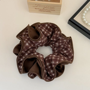 Detailed macro view of vintage brown silk and checkered fabric layered hair scrunchie