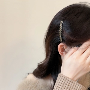 Elegant silver metal hair comb with sparkling rhinestones worn on black hair for a stylish look