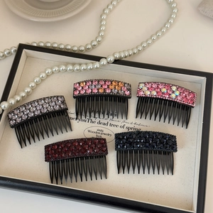 Sparkly rhinestone hair combs in various colors displayed in an elegant jewelry box