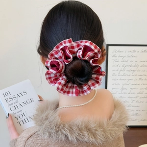 Elegant red and white gingham scrunchie shown in a stylish bun updo for women