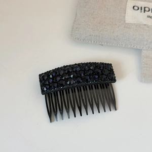 Close-up of sparkling deep blue rhinestones on a black hair side comb for women