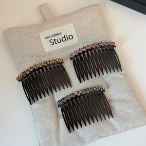 Detailed view of three-piece rhinestone hair combs in pink, champagne, and smoky grey
