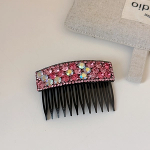 Close-up of pink and AB crystal rhinestones on a black flexible side hair comb