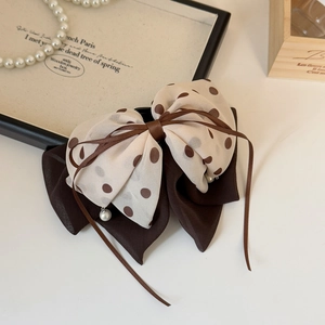 Detail view of double-layer polka dot chiffon hair claw with elegant pearl pendant