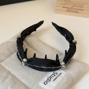 Macro detail of black silk headband with crystal accents and inner non-slip comb teeth
