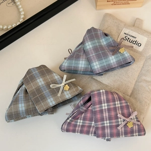 Close-up of plaid fabric hair clips with silk ribbon bows and gold flower charms