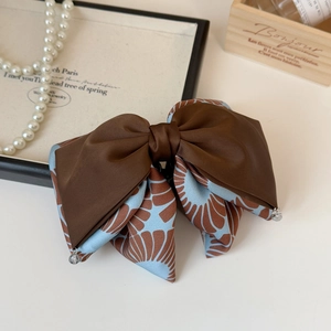 Elegant vintage French style bow hair clip with dark satin and blue floral pattern fabric