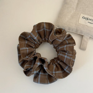 Detail of vintage brown and blue plaid fabric scrunchie with soft cotton texture