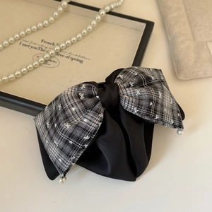 Detail of a French plaid bow hair claw with elegant hanging pearls and satin layers