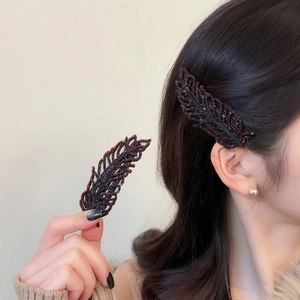 Elegant feather-shaped hair clips with deep red beads for a vintage aesthetic look