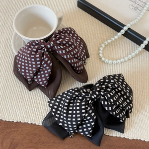 Elegant plaid bow hair clips in brown and black patterns on a stylish vintage background