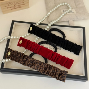 Détail de chouchous en velours et imprimé léopard avec boucles dorées gravées LOVE