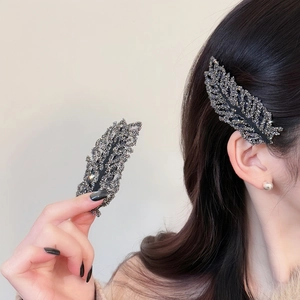 Close-up showing the sparkling leaf-shaped hair clips with dense silver rhinestones