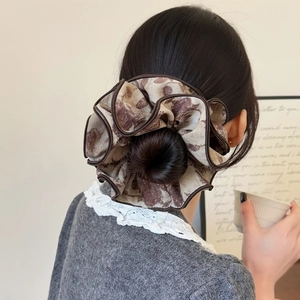Chouchou floral vintage sur chignon bas avec un design élégant en tissu rétro français