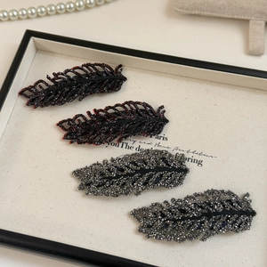 Exquisite rhinestone leaf hair clips in dark red and silver gray on a jewelry tray