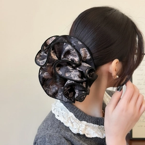 Vue détaillée d'un chouchou floral avec des plis élégants et des bords noirs volantés