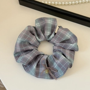 Detail of checkered plaid scrunchie with coffee bow and golden heart charm