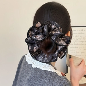 Chouchou géant vintage à imprimé rose sur mannequin portant un chignon élégant