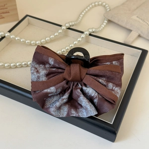 Pince à cheveux française vintage avec nœud floral bleu et texture satinée marron