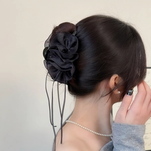 Detail der eleganten schwarzen Haarklammer aus Netzstoff mit langen Bändern im Haar