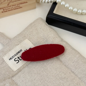 Close-up of red felt fabric hair clip with a soft matte texture for women's styling