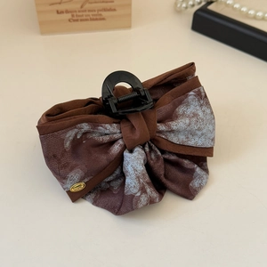 Détail de la pince à cheveux nœud à motif aquarelle avec pendentif doré love